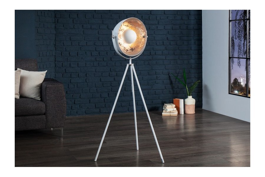 Une lampadaire trepied design en acier inoxydable et en aluminium coloris blanc et argenté
